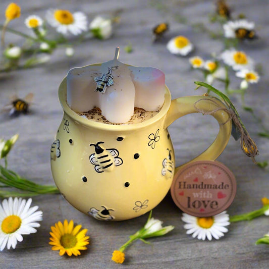 Soy candle inside a yellow ceramic mug with bee decorations